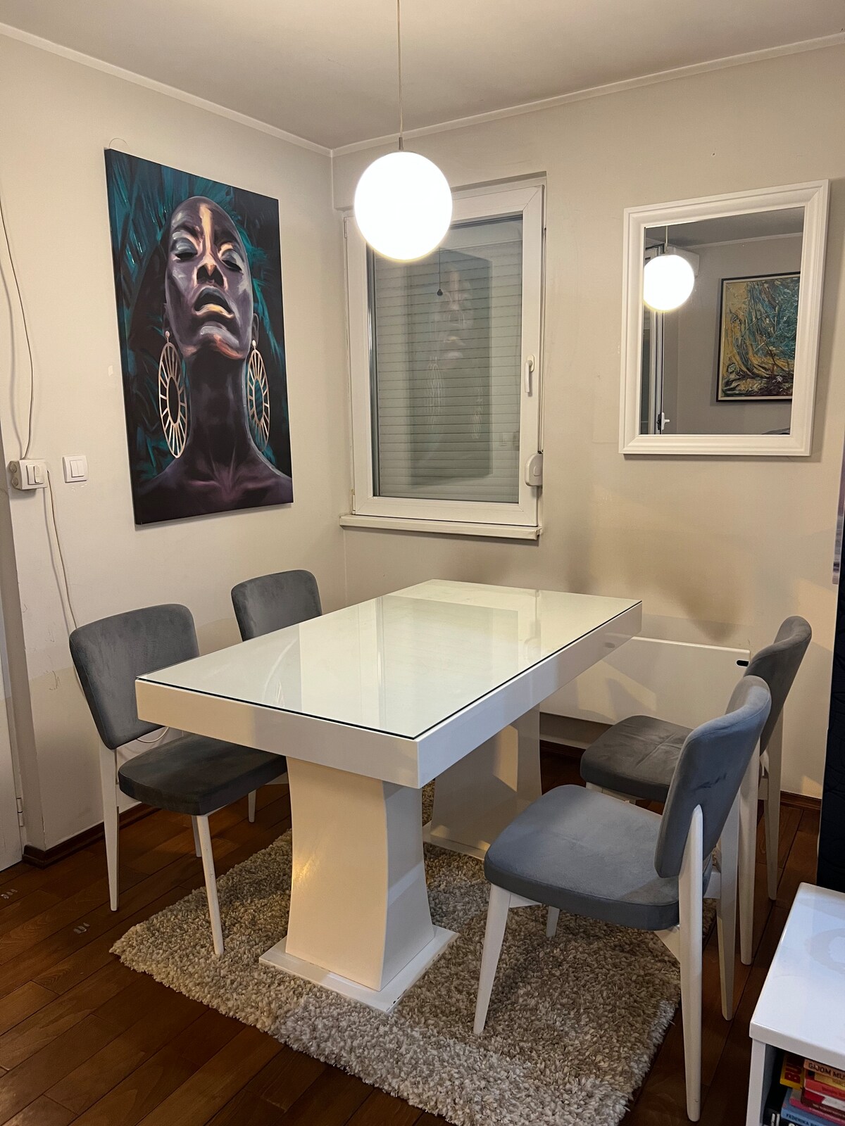 Dining table with grey velvet chairs and statement art