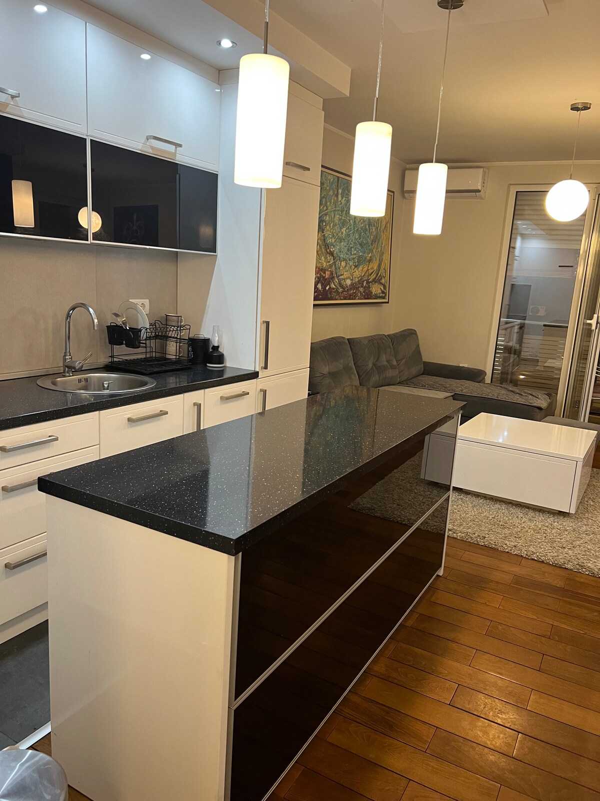 Modern white kitchen with a black granite island and bar
