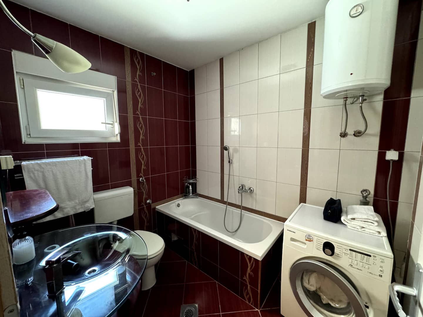 Bathroom with a bathtub and washer